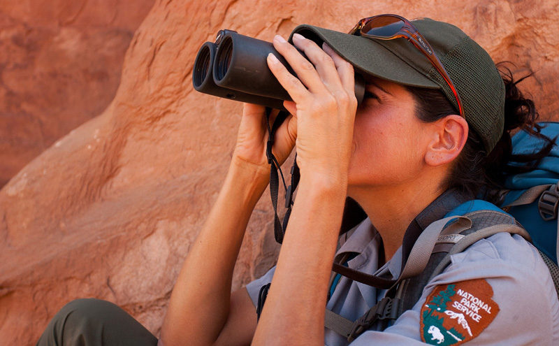 National park service ranger looking through binoculars