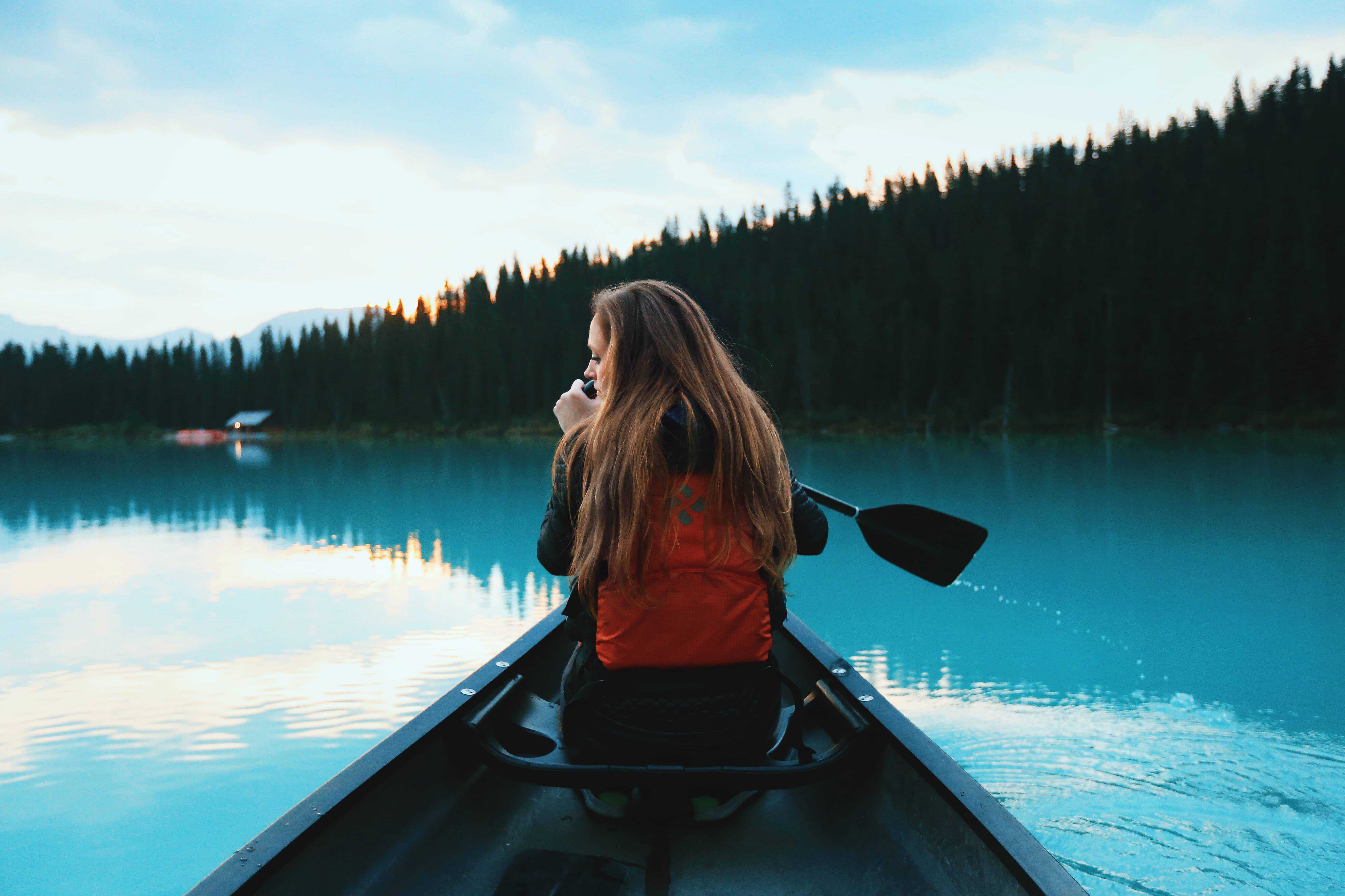 Woman paddling a canoe on an open lake