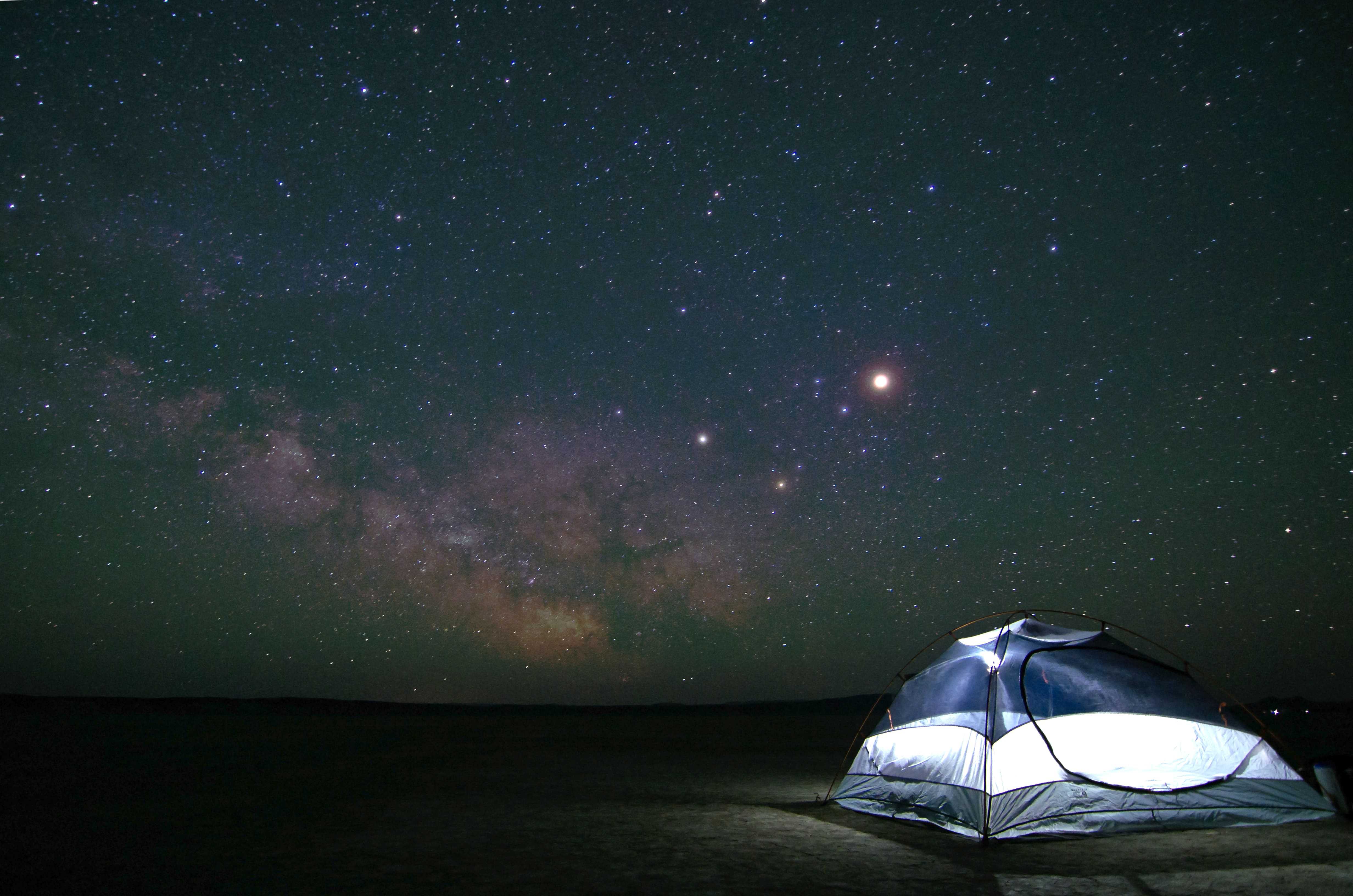 Nighttime view of a camping tent with stars in the background.