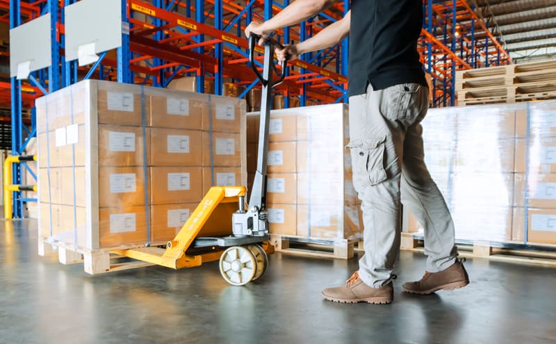 Warehouse worker working with a hand pallet jack.