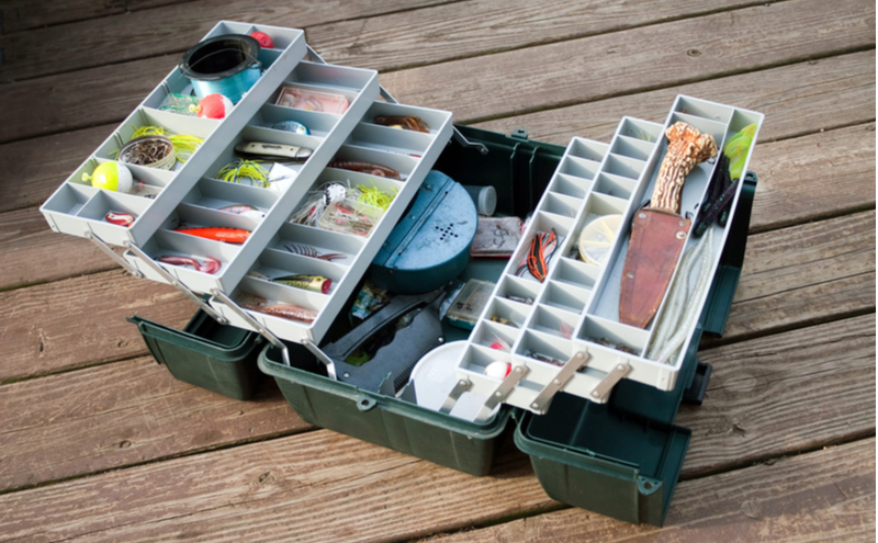 A large fisherman's tackle box fully stocked with lures and gear for fishing.