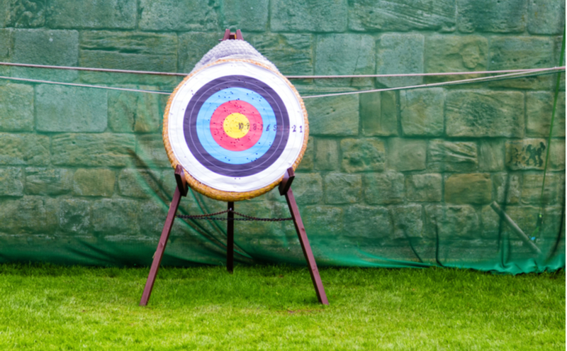 Archery target standing on the grass.