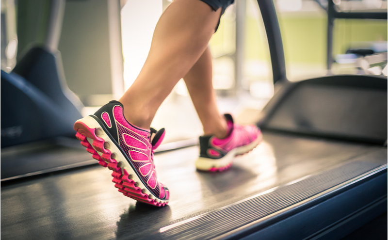 Girl walking on a treadmill in a gym.