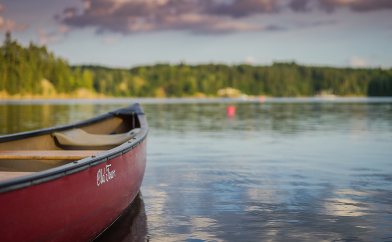 Red Old Town canoe boat on body of water.