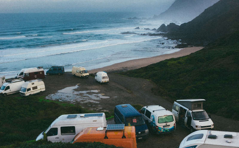 Group of Vans and RVs by coastline.