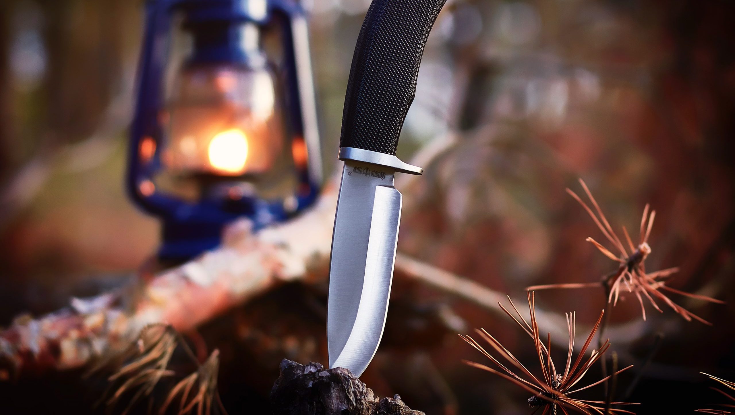 K720 steel knife with lantern in backdrop.